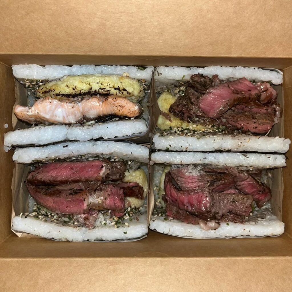 onigiri A box of gourmet onigiri sandwiches at Nigiri Station Pampanga, made with rice instead of bread, filled with premium steak, salmon, and egg, and sprinkled with furikake seasoning.